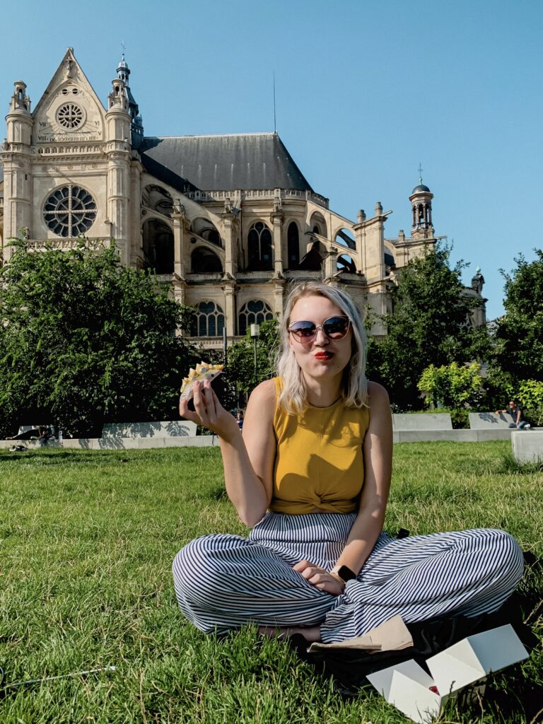 Zdjęcie przedstawiające kobietę jedzącą eklerkę w Paryżu 